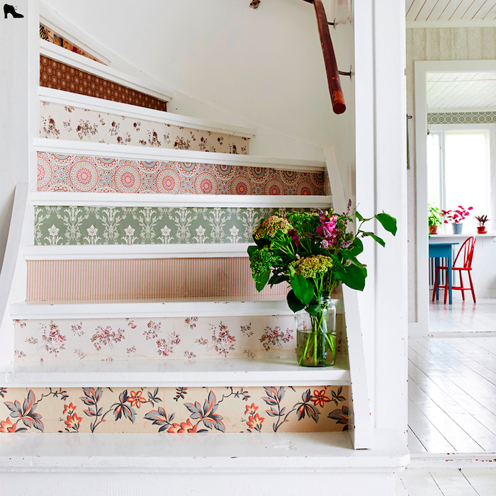 papier peint à motifs floraux et géométriques pour décorer les contremarches d un escalier repeint en blanc, main courante simpe=le en bois, bouquet de fleurs