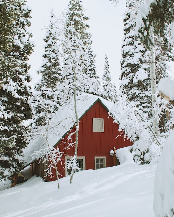 fond ecran paysage hiver avec une maison cabane ensevelie sous la neige, arbres conifères, sapins couverts de neige