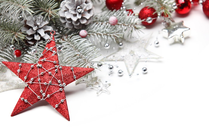 fond ecran noel en étoile rouge décorée d une guirlande de perles argentés, branches de pin enneigées, pommes de pin et boules de noel