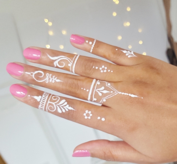 modele henné, tatouage blanc sur les doigts à design gouttes d'eau et volutes, manucure ongles rose