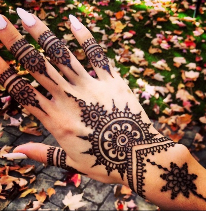 henné tatouage, dessin sur les mains et les doigts pour femme, manucure ongles longs à vernis rose pâle