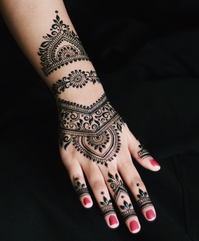 tatouage temporaire, dessin au henné noir sur les mains à design ethnique, décoration sur la peau pour femme