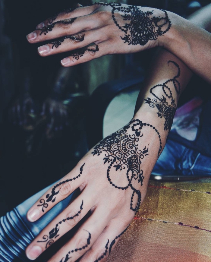 tatouage temporaire, dessin sur les mains et les doigts au henné noir, tattoo à motifs gouttes d'eau et fleurs