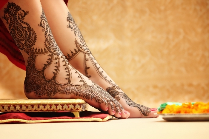 tatouage temporaire à design ethnique pour femme, dessin au henné noir sur les pieds à motifs floraux