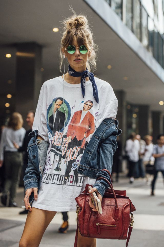 idée-coiffure-cheveux-mi-long-chignon-bun-haut-décoiffé-coiffure-avec-frange-rideau-lunettes-rondes-verre-coloré-bandana-noué-t-shirt-large-veste-en-jean coiffure avec chigon facile réalisé en haut de la tête et associé à une frange rideaux décontractée