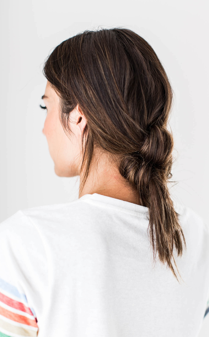 idées-coiffures-cheveux-mi-long-queue-de-cheval-nouée-effet-décoiffée-coiffure-décontractée-balayage-caramel-cheveux-marron-foncé une coiffure queue-de-cheval nouée pour un look décontractée et un joli rendu crée sans efforts