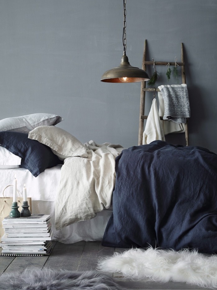 déco chambre cocooning, mur gris, linge de lit blanc et bleu marine, parquet gris, echelle decorative bois, suspension industrielle