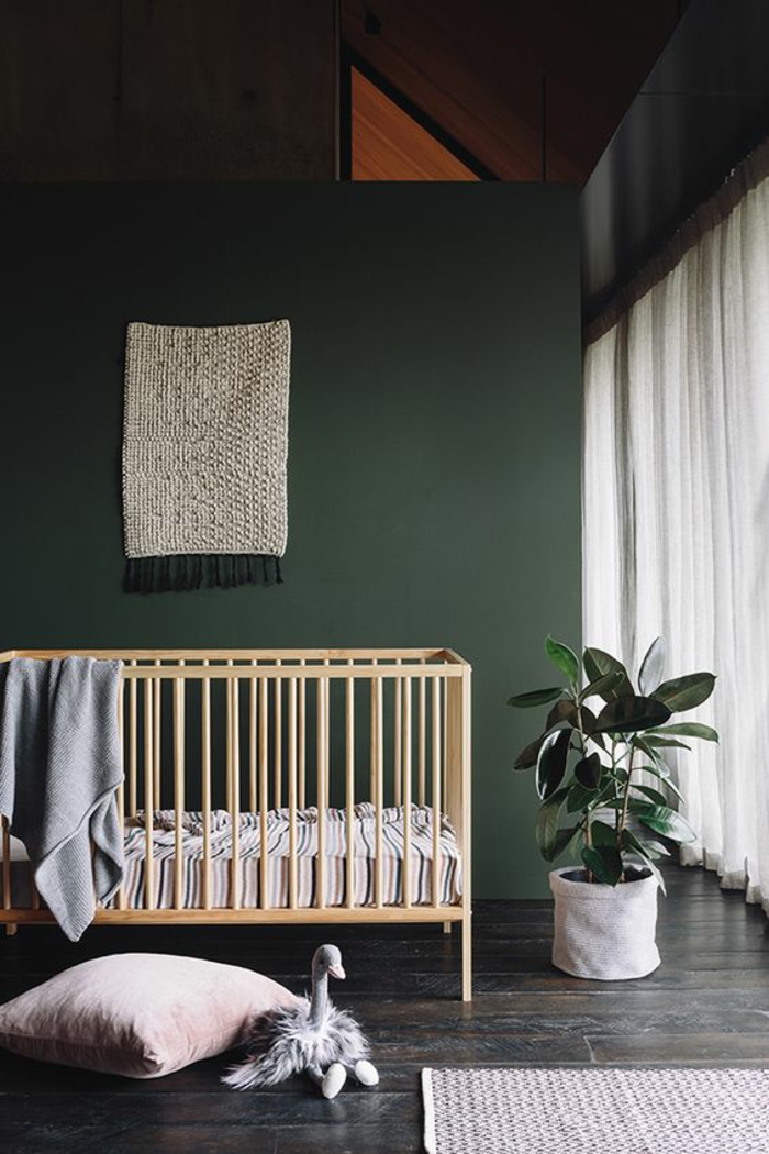 décoration chambre bébé garçon sur tous les murs avec des meubles en couleurs claires et coussin et tapis en blanc crème