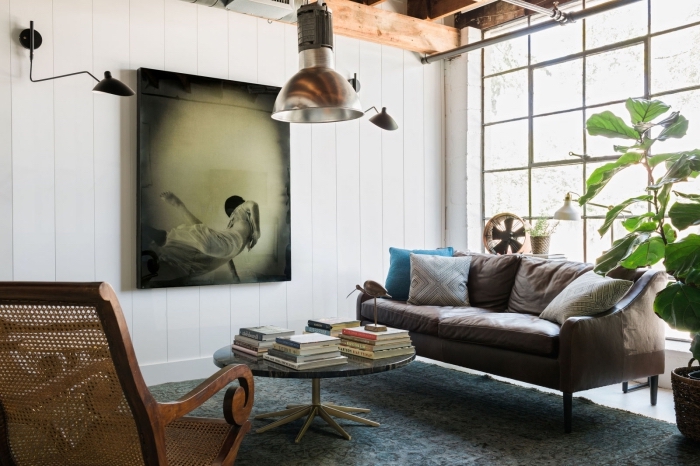 meuble style industriel, aménagement de salon loft aux murs blancs avec canapé en cuir marron et chaise en bois