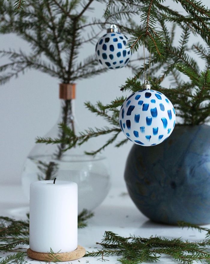 comment fabriquer une boule de noel blanche avec decoration de touches de peinture bleue, brins de pin dans un vase en verre, bougie blanche