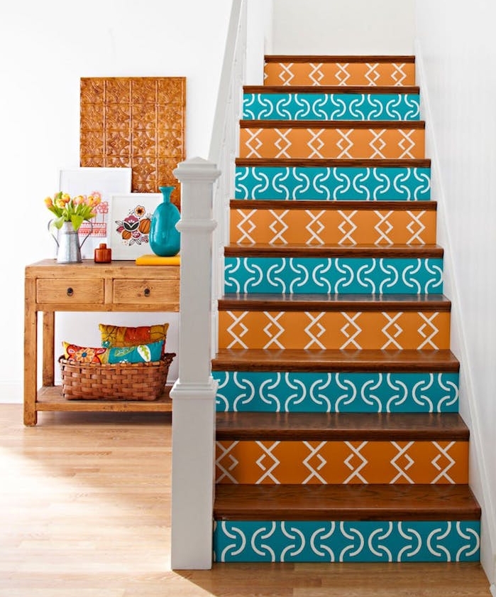 comment renover un escalier en bois, contremarches décorés de stickers autocollants couleur orange et bleue à motifs geometriques, parquet clair et meuble en bois rangement accessoires decoratifs