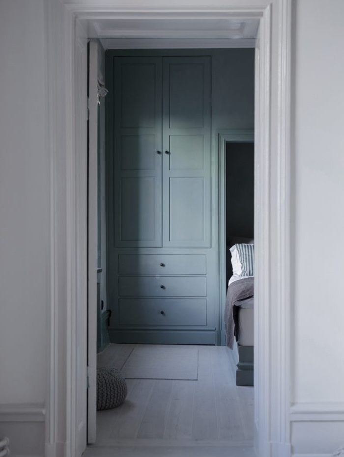 amenagement chambre avec armoire vert gris, linge de lit blanc et gris, parquet clair, murs couleur blanche