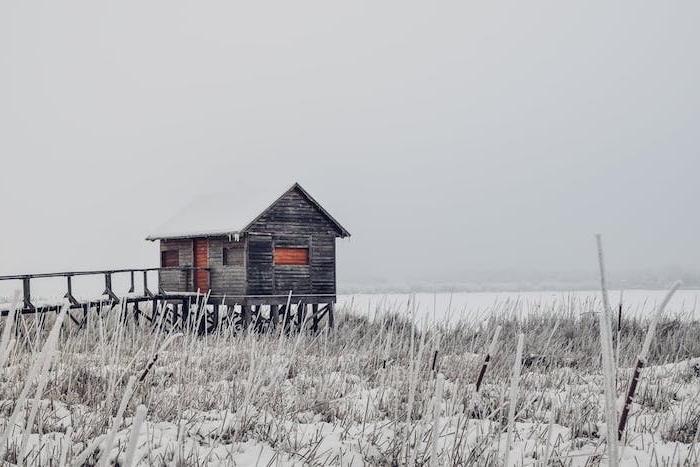paysage hiver fond ecran, une plaine enneigée, une cabane simple au bord d un lac sous l emprise de la neige