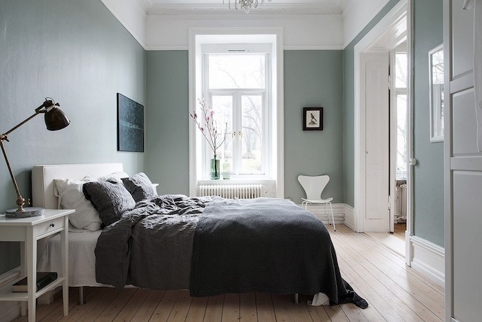 chambre aux murs couleur bleu celadon, deco scamdimabe, parquet clair, lit blanc avec linge de lit gris, table de nuit blanche