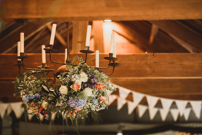 decoration mariage champetre de lustre baroque noire avec des bougies et deco de fleurs des champs