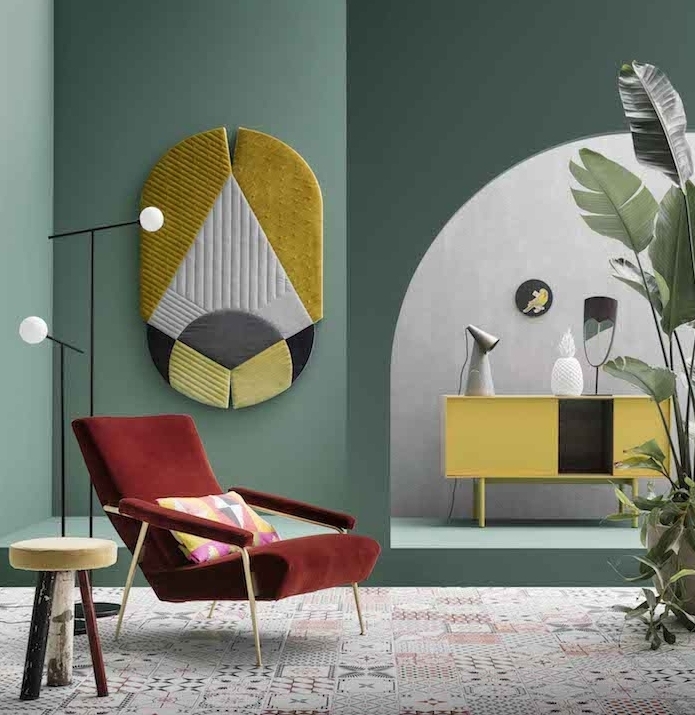 mur couleur vert de gris en combinaison avec des accents jaunes, revêtement sol en mosaique orientale, fauteuil rouge, plantes vertes, coussins à triangles colorés, commode jaune