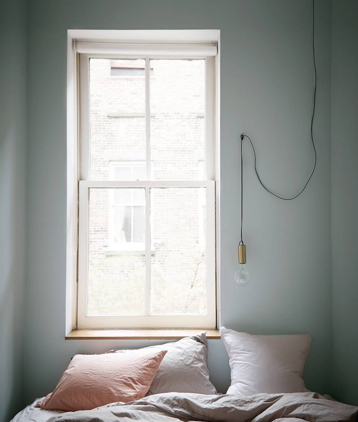 idée déco chambre adulte, petit espace, mur couleur gris clair, linge de lit gris, coussins rose, gris clair et saumon, suspension ampoule