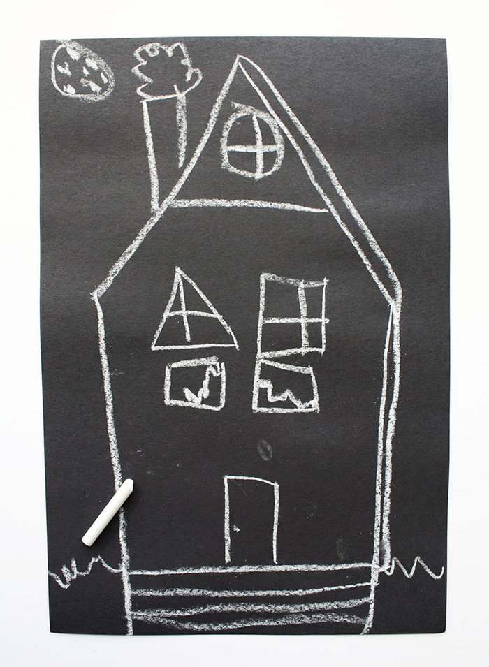 une activité manuelle automne pour réaliser une décoration d halloween avec les enfants, une maison hantée en papier cartonné noir dessinée à la craie 