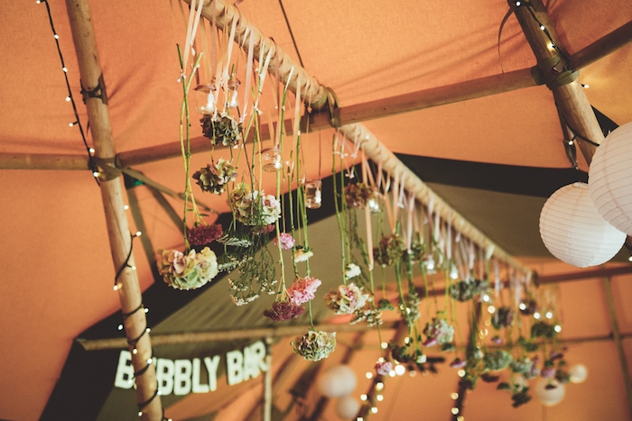 décoration champêtre, des fleurs suspendues par des rubans d'un poteau en bois, guirlandes lumineuses, lanternes blanches