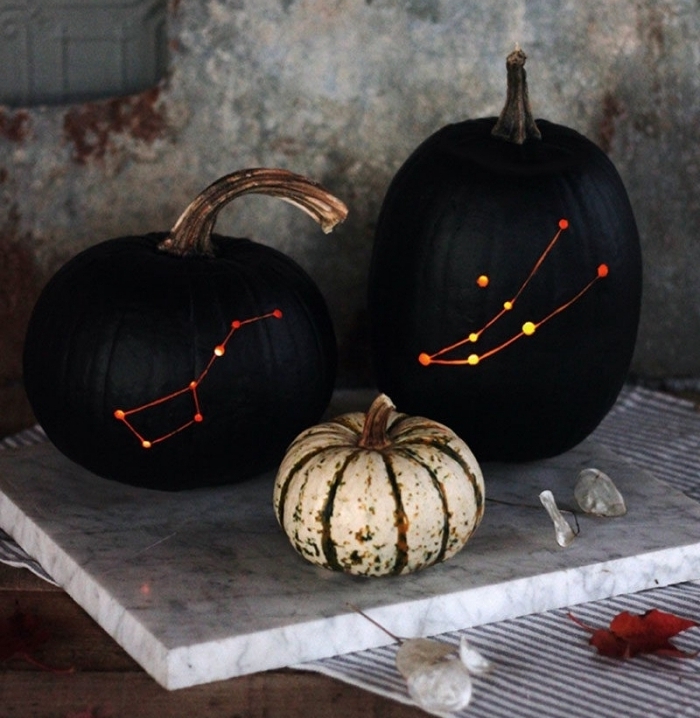 activité manuelle halloween, grandes citrouilles peintes noires avec constellations lumineuses