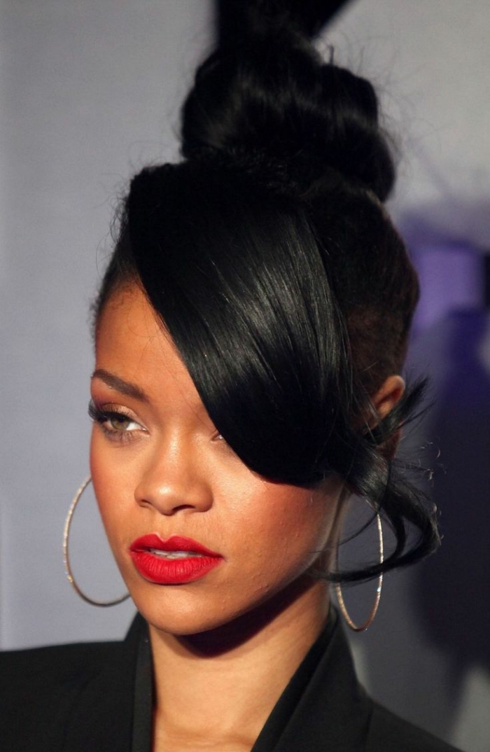 idée coiffure cheveux longs, coiffure célébrité de Rihanna, coiffure cheveux attachés en chignon haut avec frange longue