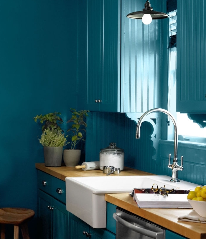 modele de cuisine ancienne campagne couleur bleu canard avec plan de travail bois, évier blanc, pots d herbes aromatiques, lavabo blanc et robinetterie argent