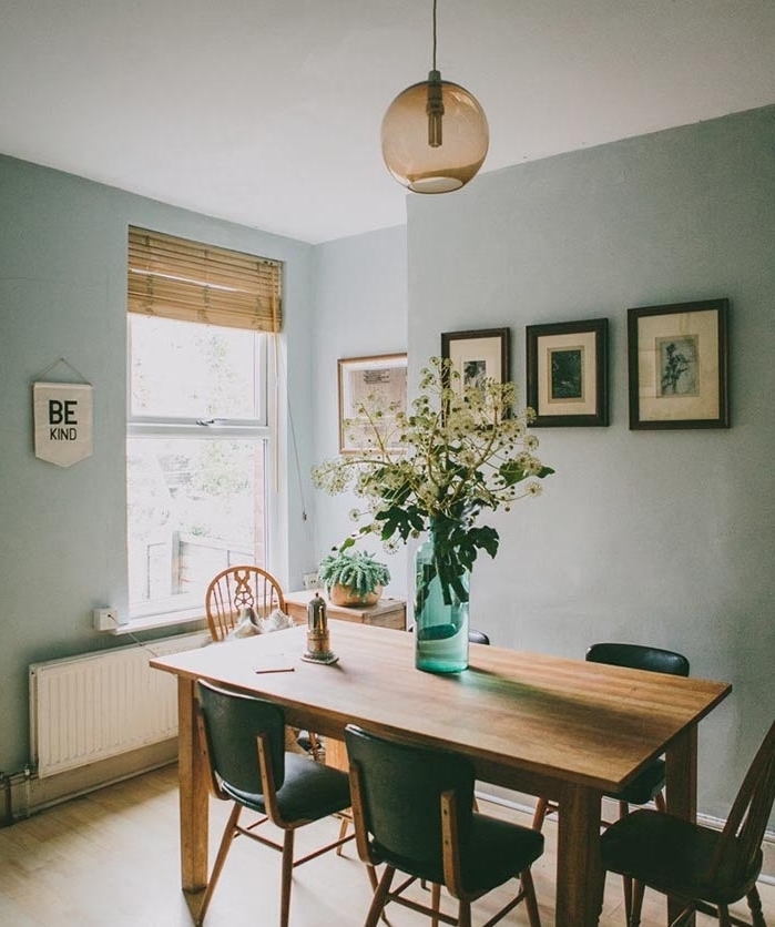 idee amengamenet salle à manger aux murs peinture vert de gris, nuance céladon, table et bois et chaises noires, suspension boule, parquet clair