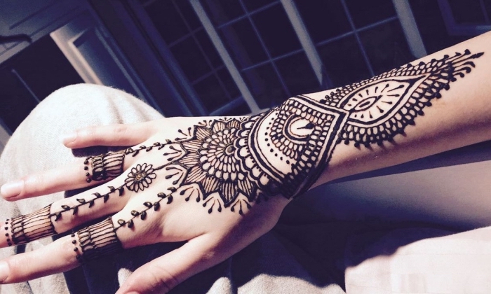 tatouage au henné noir sur la main, dessin ethnique pour femme, tattoo non permanent à design florale