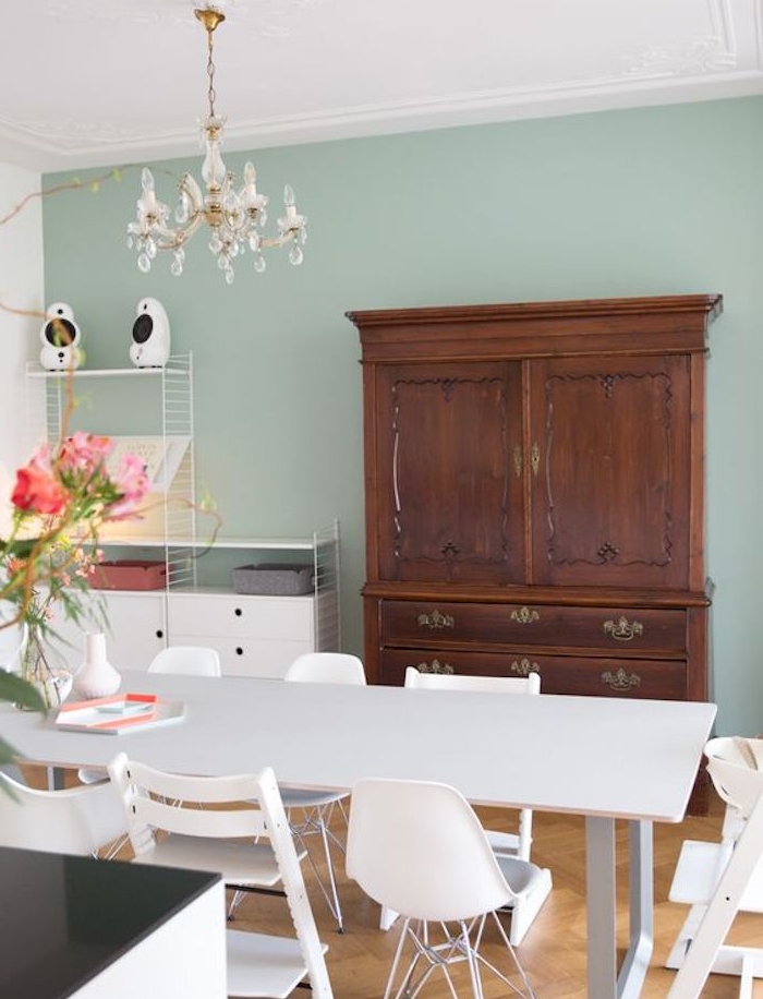 deco salle a manger avec murs couleur vert céladon clair, table et chaises salle à manger style scandinave, armoire en bois vintage, lustre élégant