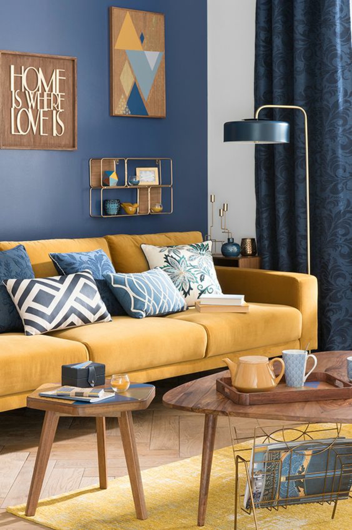 couleur bleu gris azur couleur dans le salon avec n canapé en couleur jaune moutarde avec des tableaux décoratifs aux murs et des rideaux en couleur bleu gris