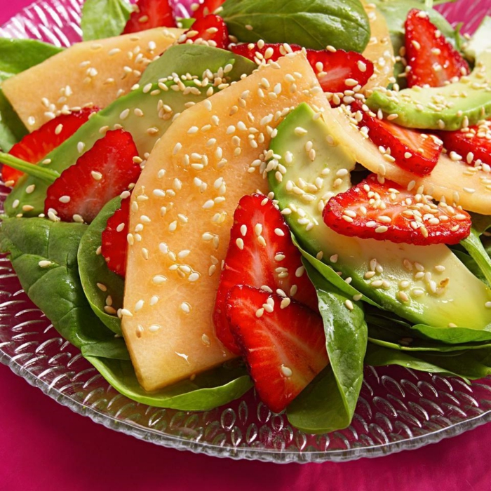 presentation salade composée, graines de sésame, fraises, mangue et épinards