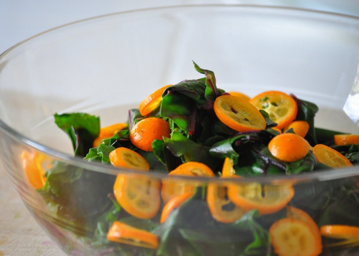 recette salade été, kumquats, feuilles de salade fraîche dans un bol en verre