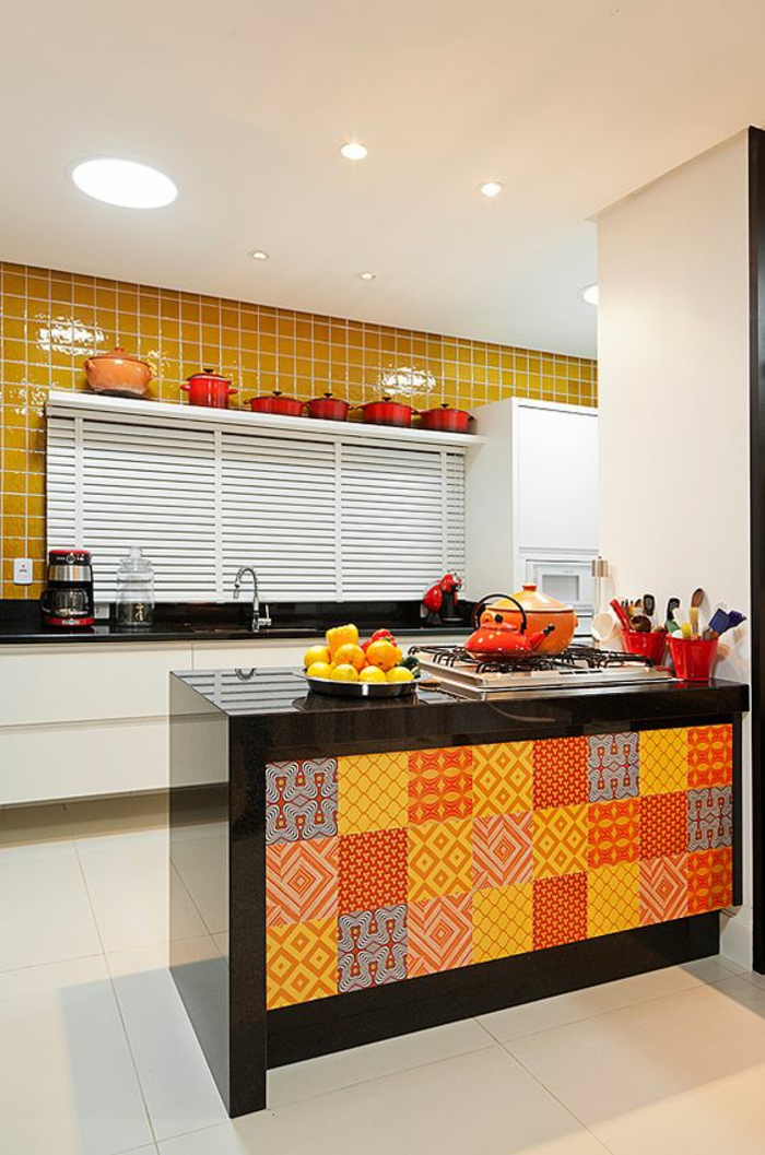 quelle couleur pour les murs d'une cuisine, des briques jaunes, meuble blanc avec plan de travail en surface noire brillante, grand meuble bar de cuisine en noir, utilisé comme séparateur d'espace, revêtu de carrés en rouge, orange et gris aux motifs géométriques 