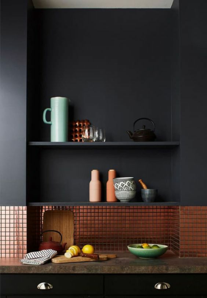 quelle couleur pour les murs d'une cuisine, gris fumée, avec des étagères en gris fumée, meuble en noir avec plan de travail en taupe, revetement de la partie basse du mur en cuivre, avec des motifs carrés 