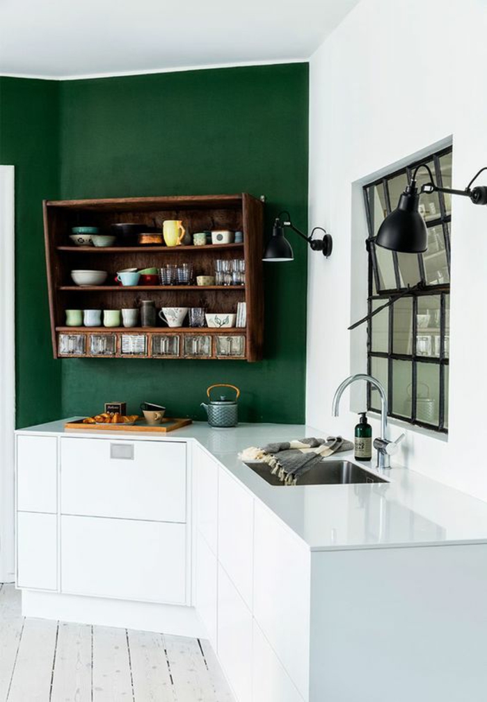 quelle couleur pour les murs d'une cuisine, vert émeraude, avec grand meuble de rangement en marron, type caisse, en style vintage, meubles blancs avec finition lisse, luminaire mural pliable en métal noir 