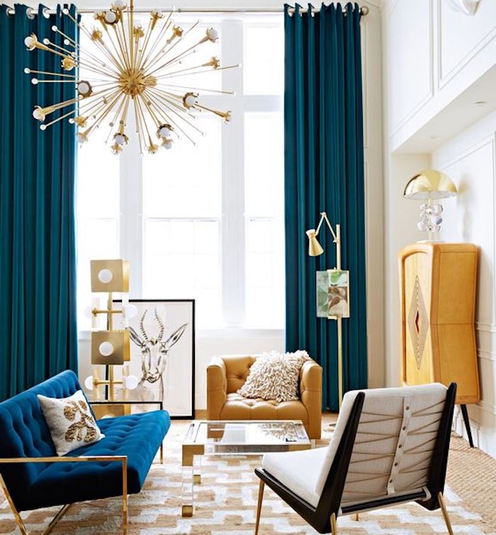 rideau bleu pétrole dans un salon spacieux, tapis blanc et jaune, canapé bleu marine, armoire et fauteuil jaune, décoration et suspension boule dorée