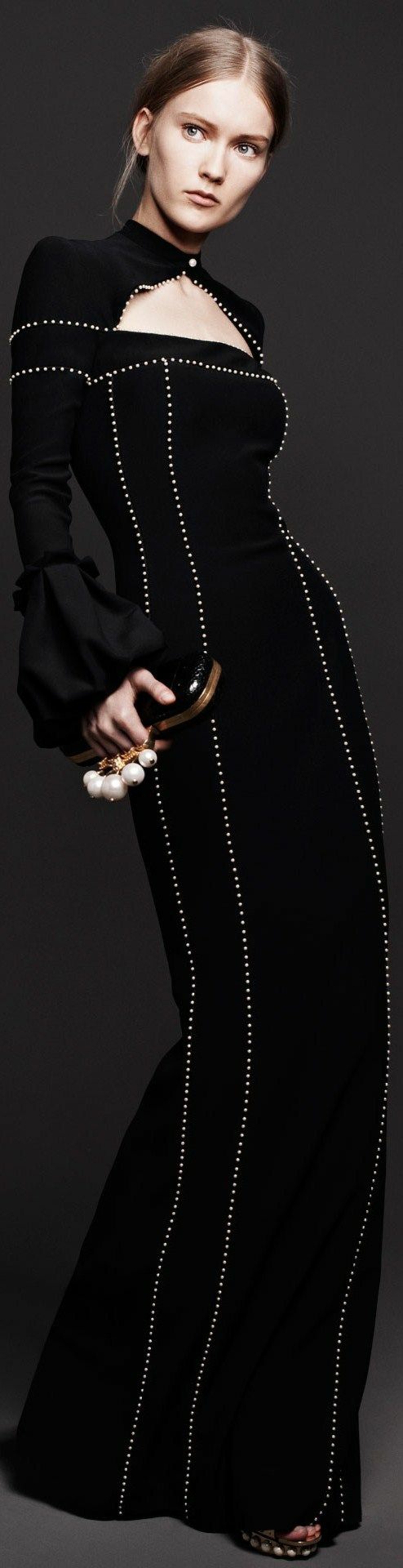 robe longue moulante en noir avec des minuscules détails blancs petits boutons et décolleté fermé fermé avec un petit bouton blanc sur le cou