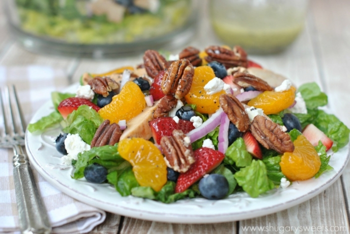 salade composée d'été aux oranges, noix de pecan, fraises, laitues, orange, myrtilles