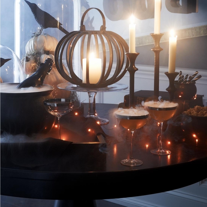 préparatifs halloween, déco de table avec verre de champagne et bougies, modèles de citrouilles blanches