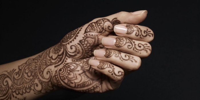 modele henné, dessin sur mains pour femme, tatouage temporaire à motifs volutes et floraux