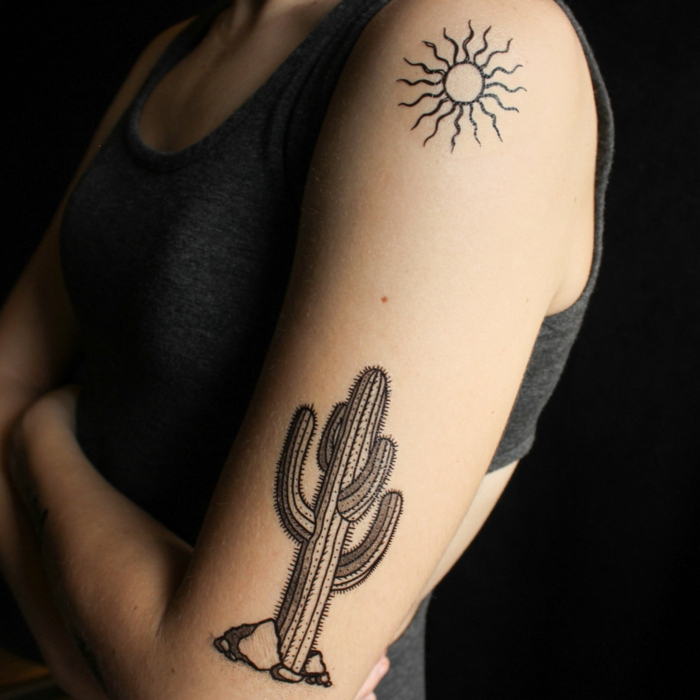 tatouage bras femme, tatouage symbolique soleil et cactus, tatouage encre noire