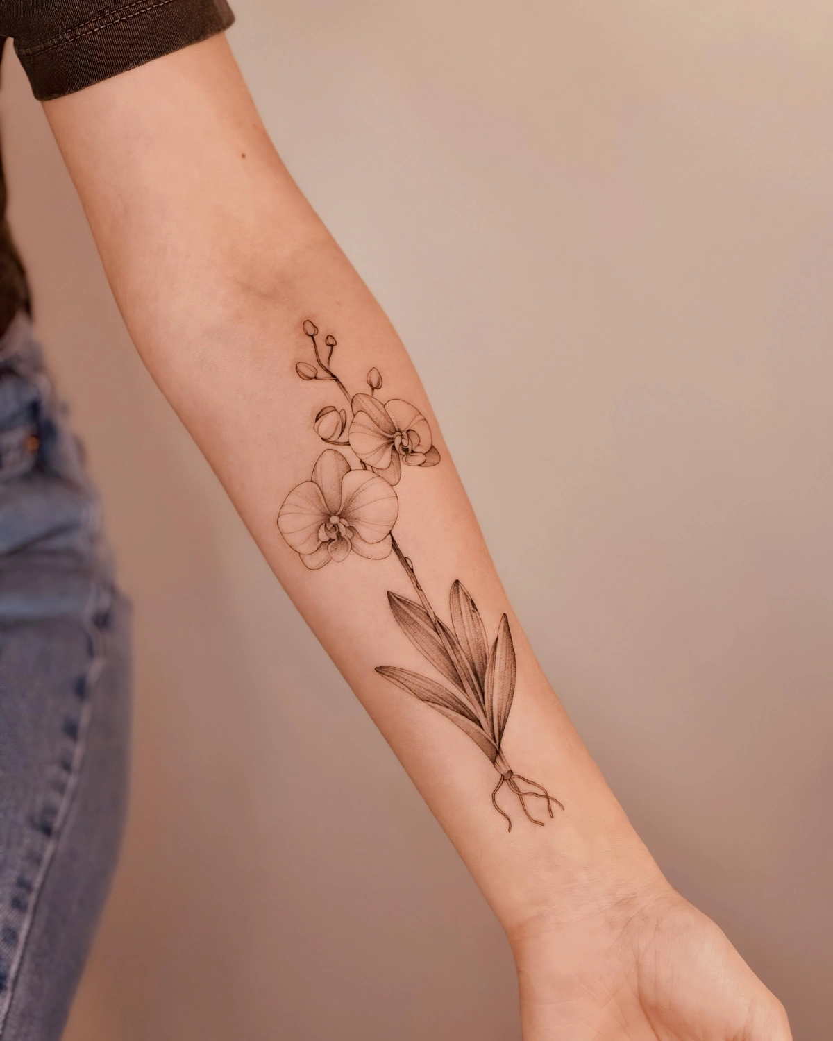 tatouage fleur bras femme feuilles jeans t shirt manche noire