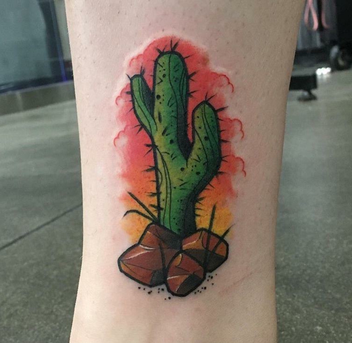 tatouage mollet femme, cactus avec des pierres, paysage artistique symbolisant le désert