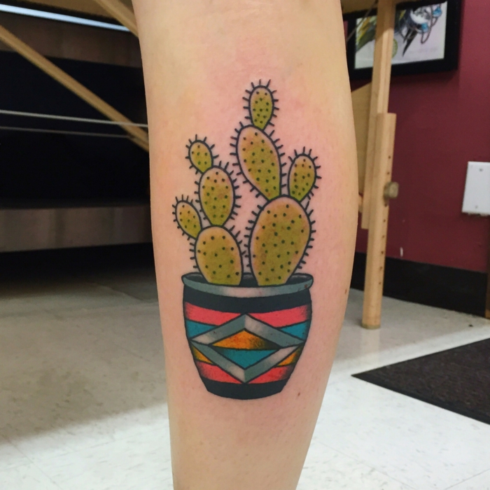 tatouage mollet femme, pot de fleur en plusieurs couleurs avec un grand cactus