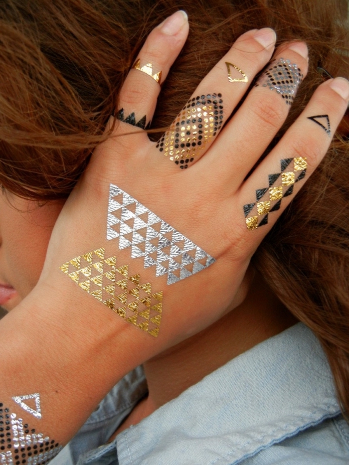 tatouage temporaire, dessin sur la peau en noir et or, tatouage sur mains et doigts pour femme