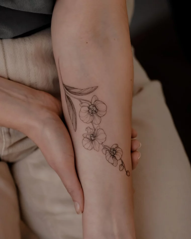 tatouage poignet femme fleur dessin realiste mains pantalon beige