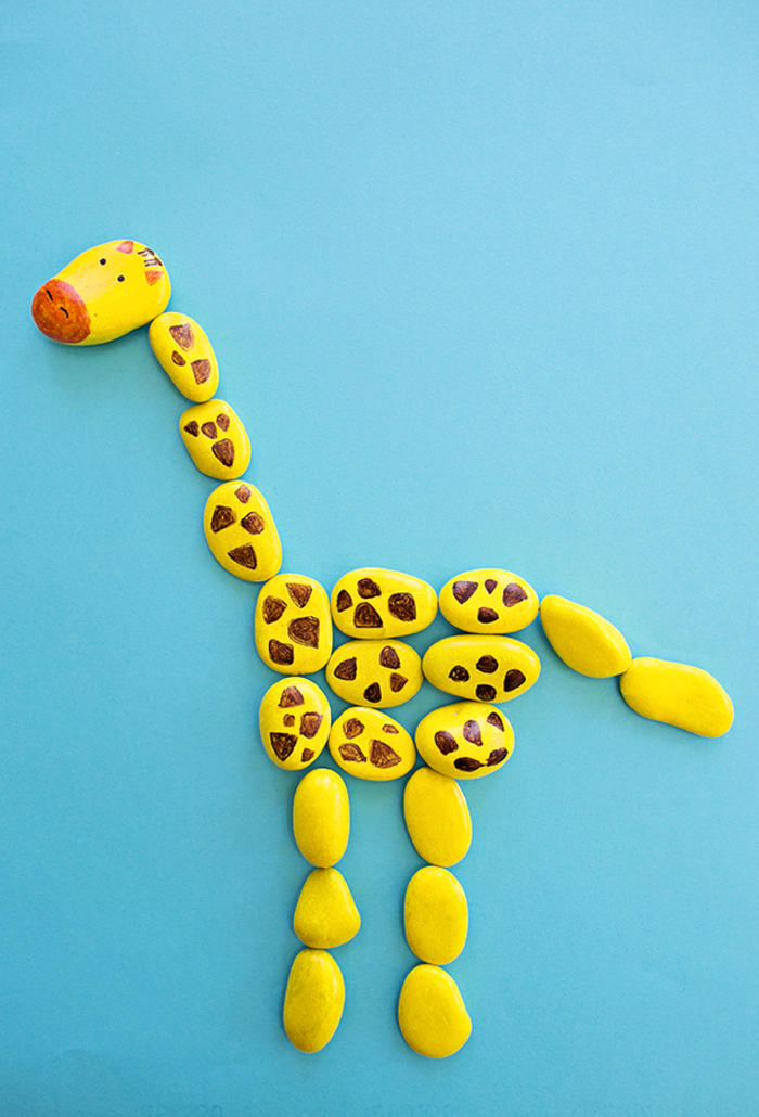 un bricolage facile avec des galets décoratifs pour occuper les enfants à la maison, créer un puzzle girafe avec des galets peints