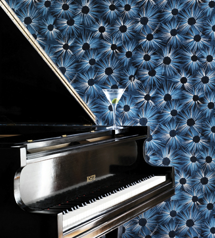 papier peint trompe l'oeil en bleu royal et noir, pour les murs d'un salon, avec piano classique et un verre de cocktail