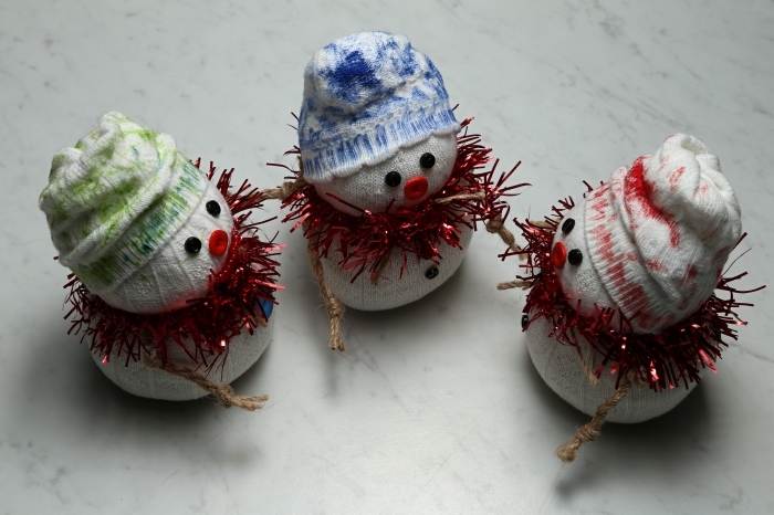comment faire un bonhomme de neige, petits doudou fabriqués de chaussettes et décorés avec guirlande de Noel