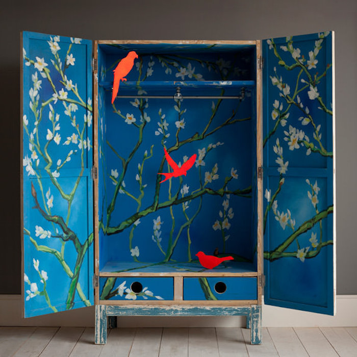 idée comment relooker armoire ancienne, repeindre un meuble en bois de couleur bleue, motif fleuri et silhouettes d oiseaux rouges